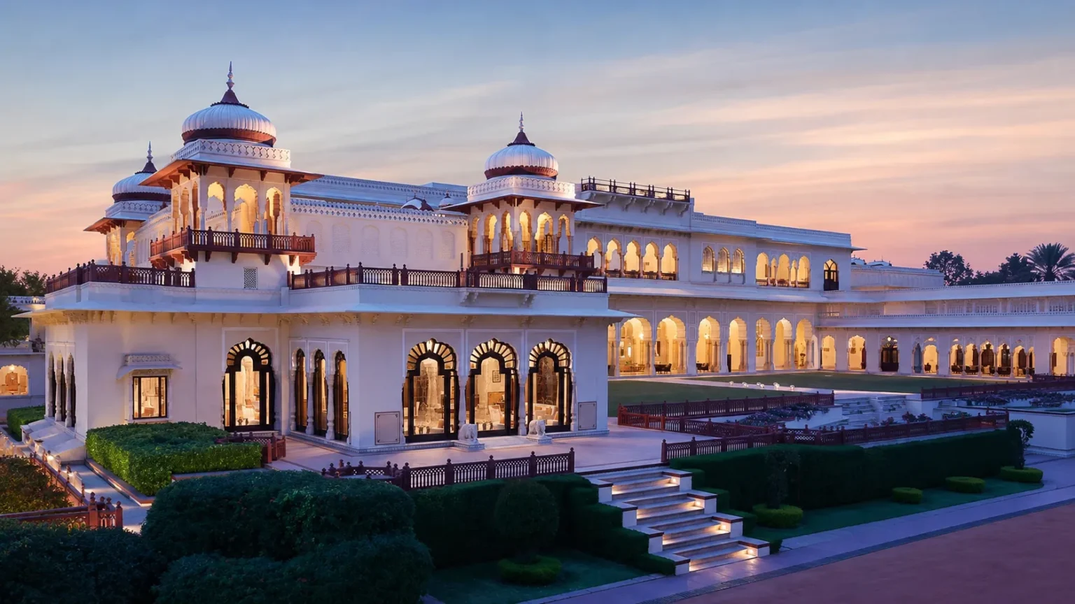 Exterior view of Rambagh Palace Jaipur with lush gardens, heritage architecture, and luxury palace surroundings.