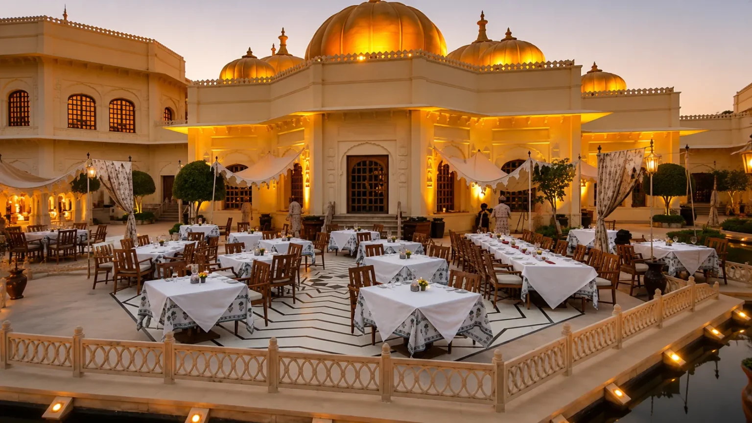 Courtyard dining area at The Oberoi Rajvilas Jaipur featuring illuminated domes, elegant architecture, and luxury outdoor seating.