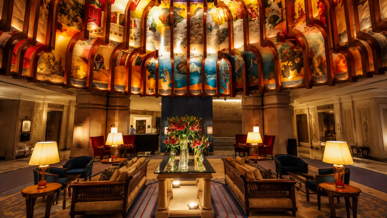 Luxury suite at ITC Maurya New Delhi with king-size bed, stylish living area, wooden interiors, and elegant furnishings.