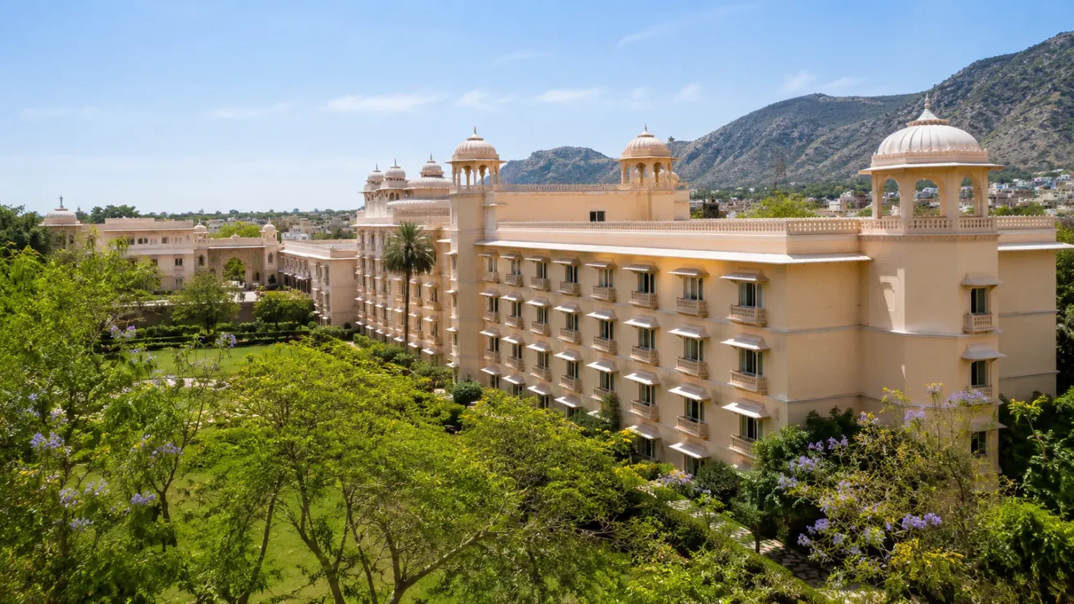 Trident Jaipur hotel surrounded by gardens with views of the Aravalli Hills and elegant palace-inspired architecture.