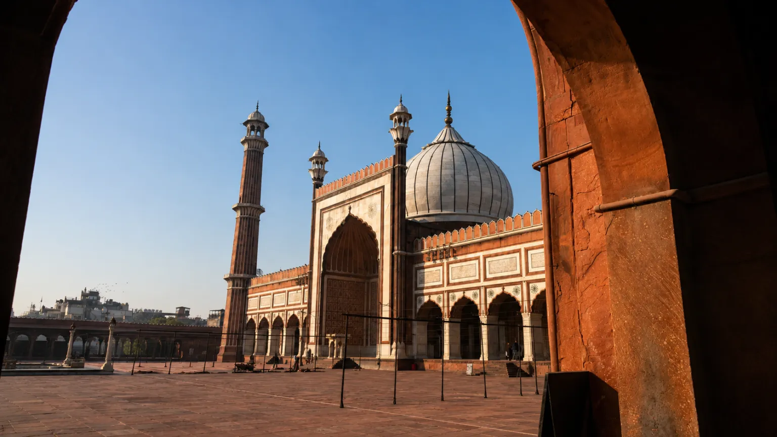 View of Jama Masjid's grand courtyard, domes, and towering minarets in Old Delhi.