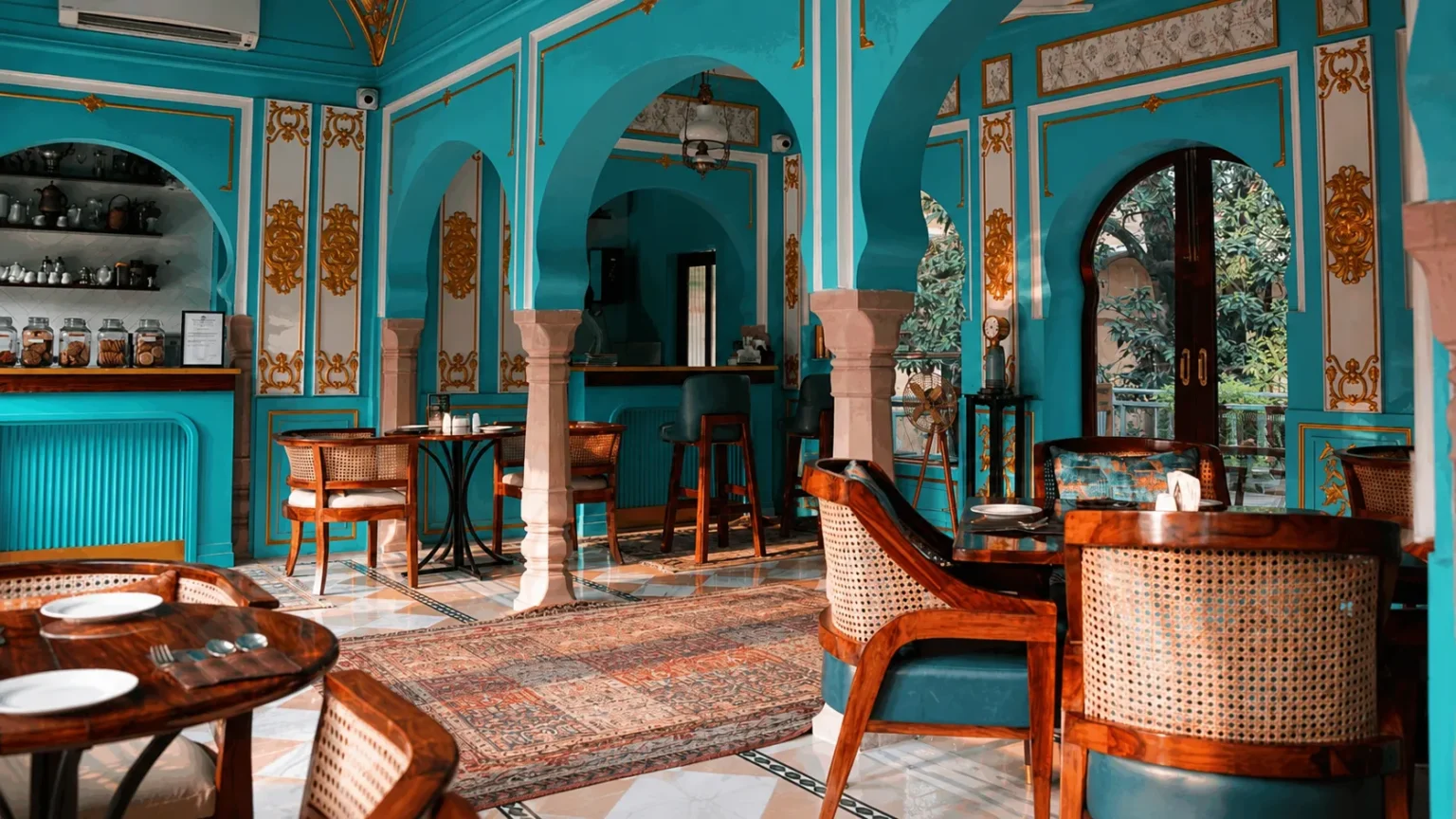 Heritage café at Narain Niwas Palace Jaipur with turquoise interiors, arched architecture, and vintage furnishings.