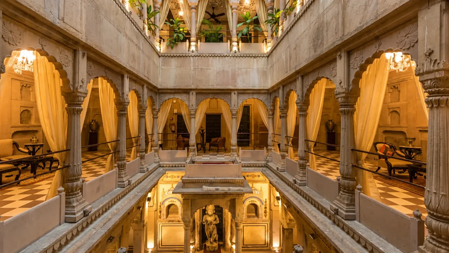 Elegant heritage courtyard at BrijRama Palace in Varanasi featuring carved stone arches, traditional architecture, and warm lighting.