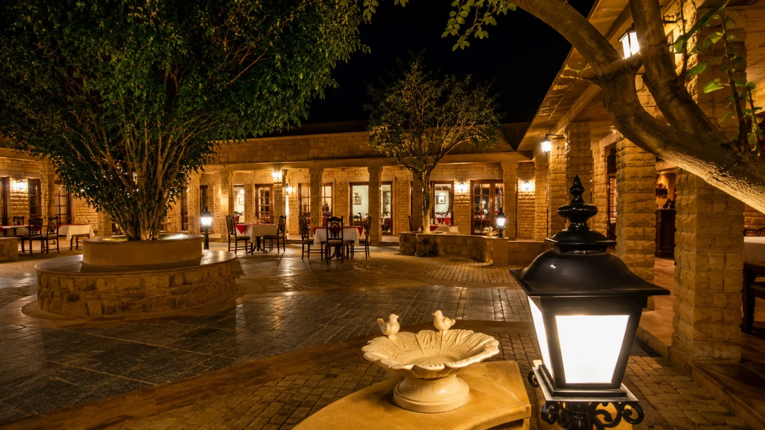 Outdoor courtyard restaurant at Hotel Rawalkot Jaisalmer illuminated with warm lights and heritage architecture.