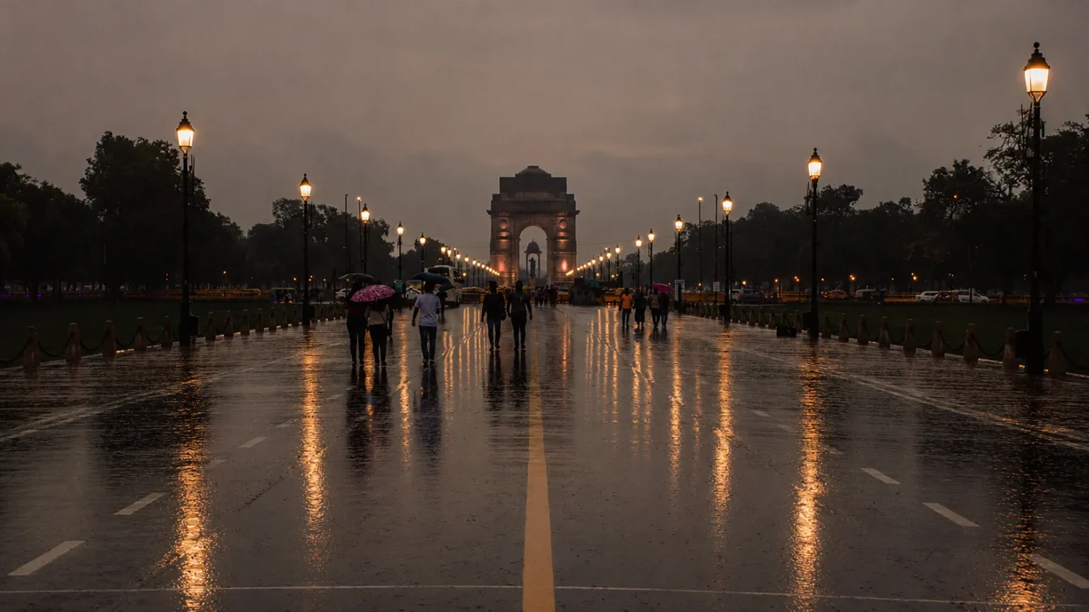 India Gate illuminated on a rainy evening with reflections of streetlights on the wet boulevard and visitors walking with umbrellas.