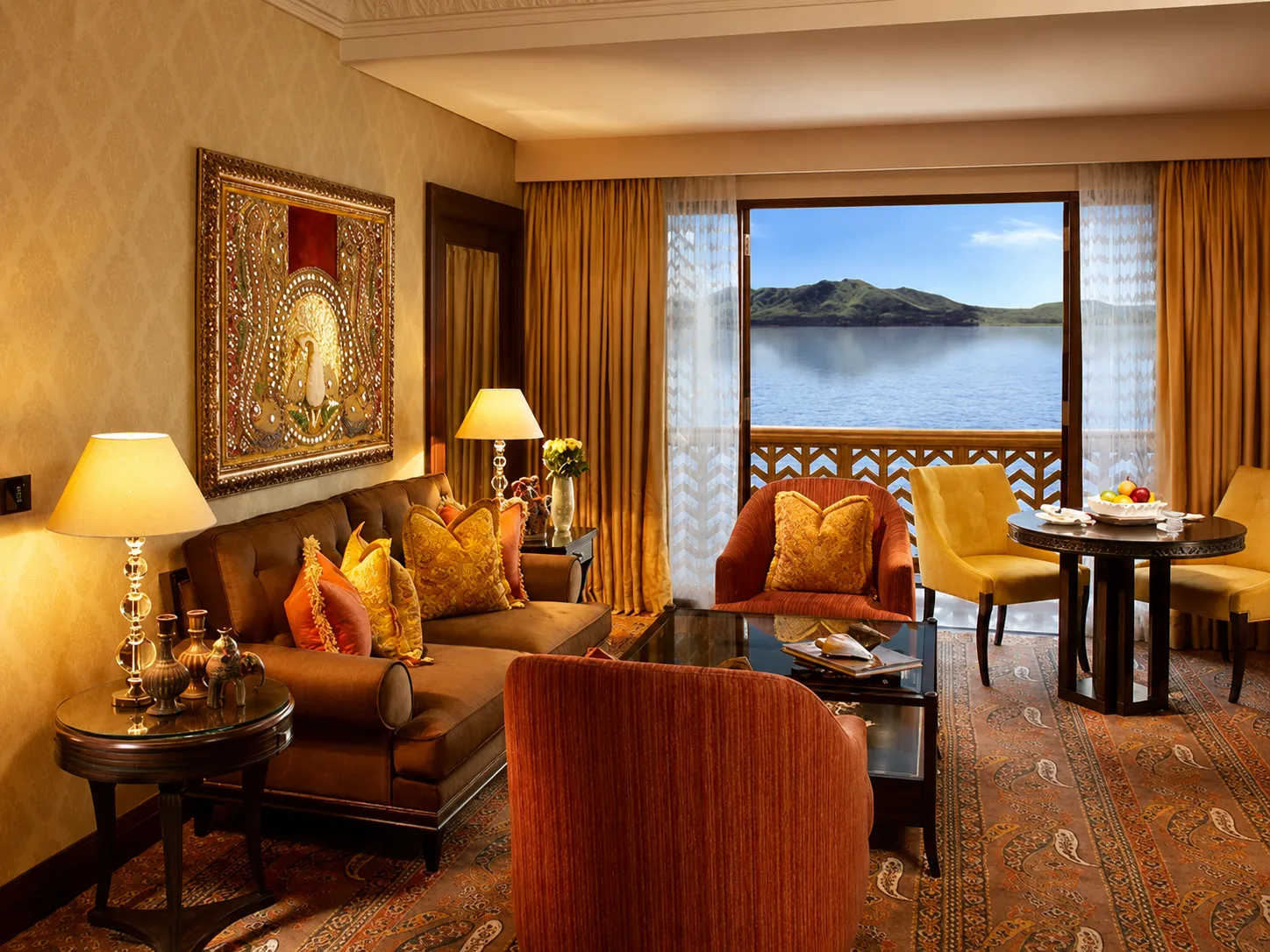 Elegant suite at The Lalit Laxmi Vilas Palace overlooking Fateh Sagar Lake with classic interiors.