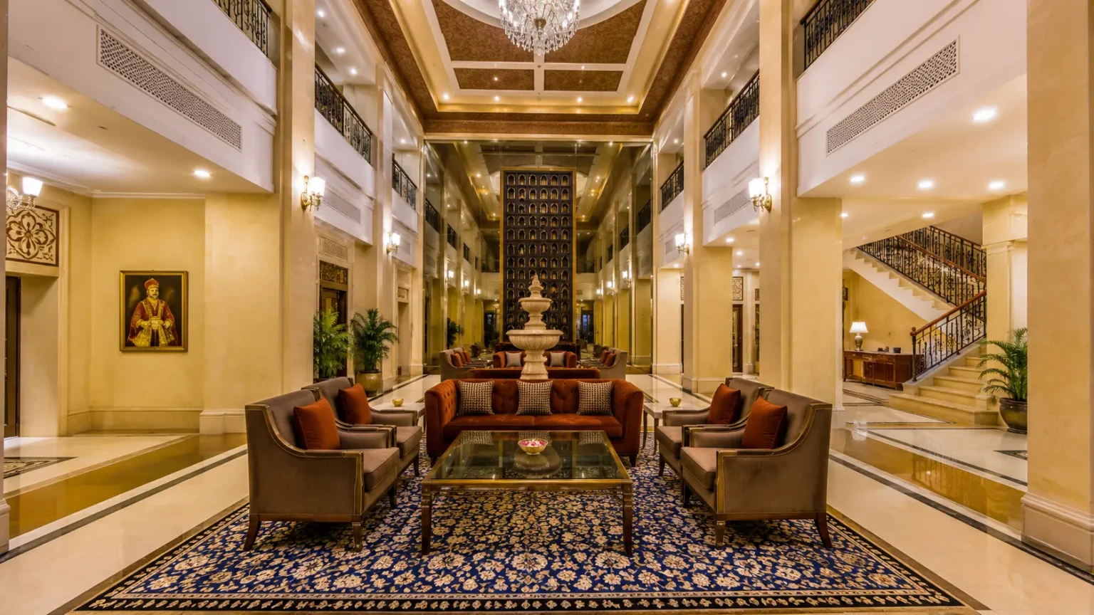 Spacious atrium lobby at Radisson Hotel Varanasi with luxury seating, grand chandelier, and modern architecture.