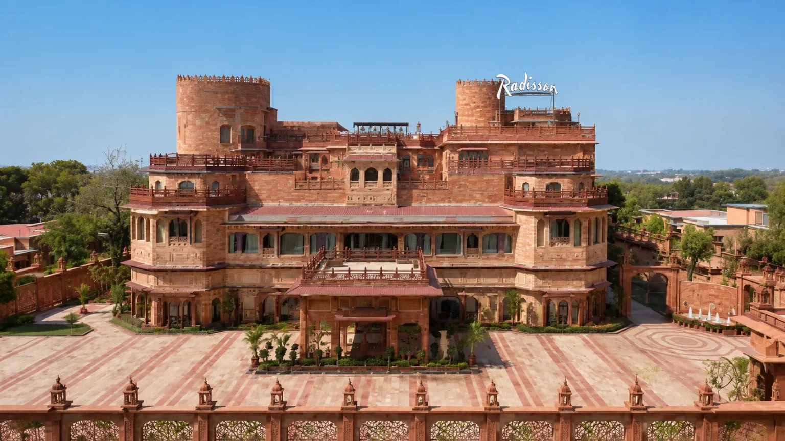 Front view of Radisson Jodhpur featuring majestic Rajasthani-inspired architecture, sandstone façade, landscaped courtyards, and elegant heritage design in daylight.