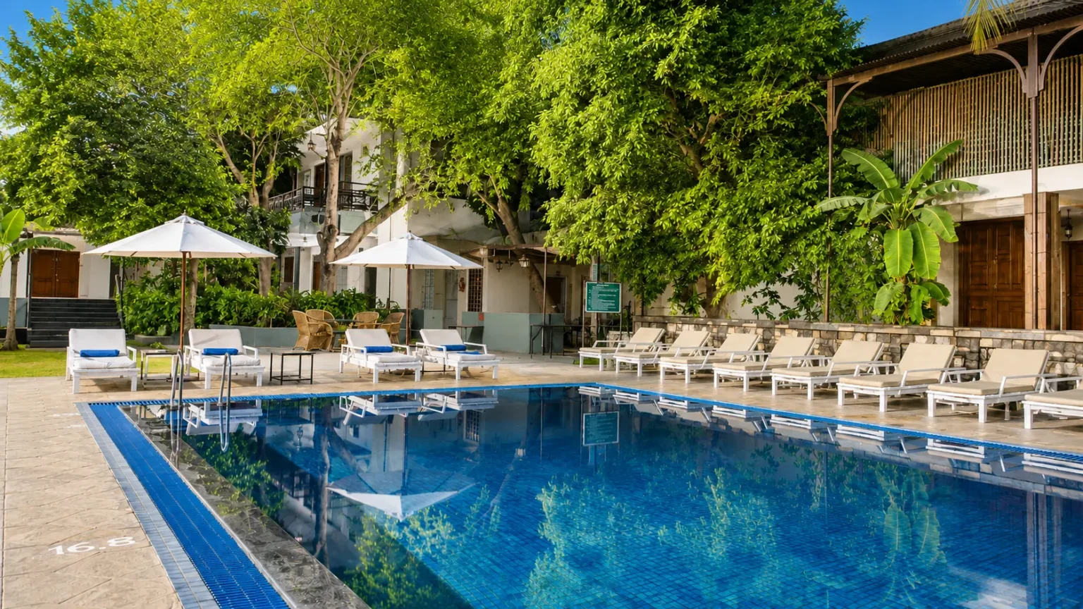 Ranthambore Regency resort featuring a large outdoor swimming pool, landscaped gardens, and elegant resort buildings.