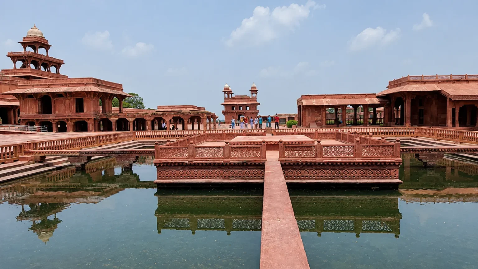 Historic sandstone courtyard with reflecting pools and Mughal buildings at Fatehpur Sikri near Agra, India.