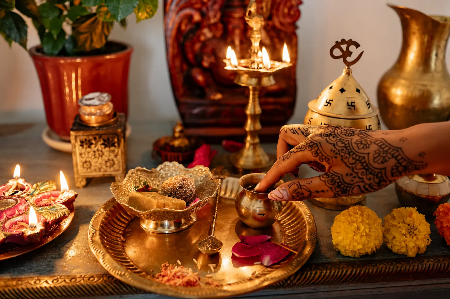 A decorated hand performing a Diwali puja with brass lamps, flowers, sweets, and sacred offerings on a traditional prayer altar.