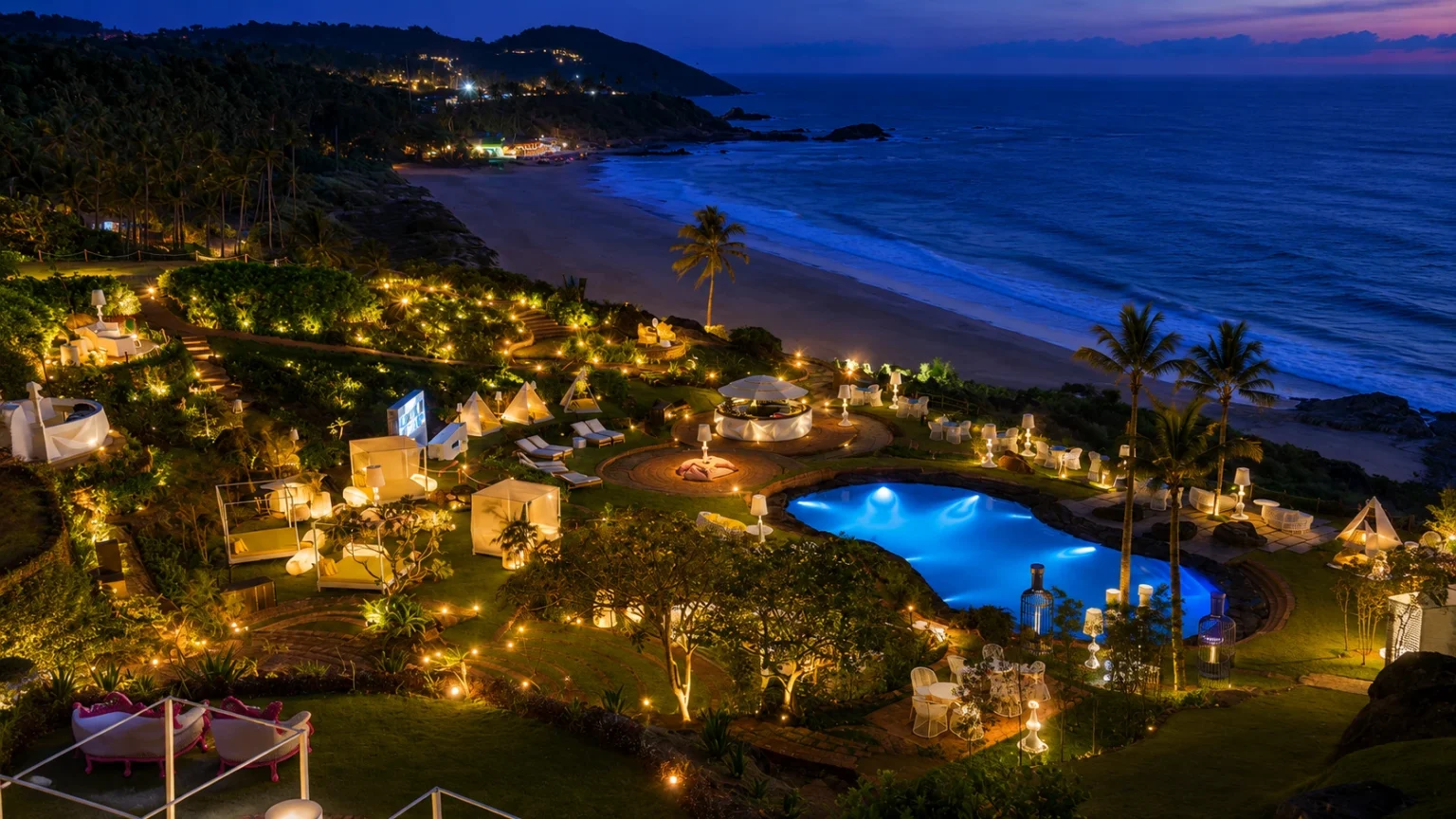 W Goa luxury beachfront resort illuminated at night with infinity pool, landscaped gardens, and Arabian Sea views.