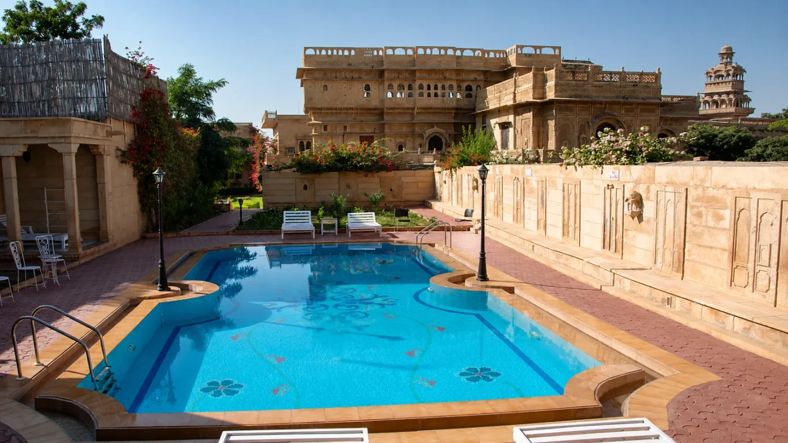 Poolside at WelcomHeritage Mandir Palace Jaisalmer showcasing heritage architecture and traditional artwork.