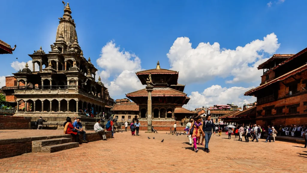 Bhaktapur Durbar Square with historic Newari temples, pagodas, and visitors under a blue sky
