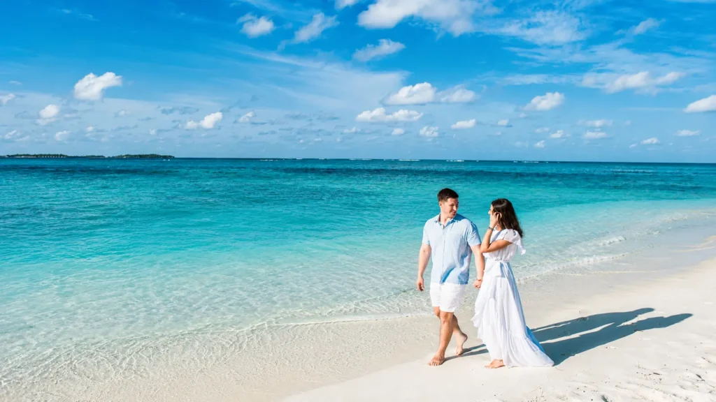 Couple walking on a white sand beach in the Maldives