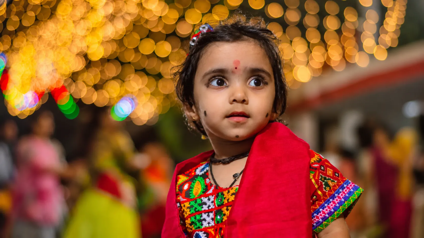Young child in traditional Indian clothing enjoying the festive atmosphere during Durga Puja