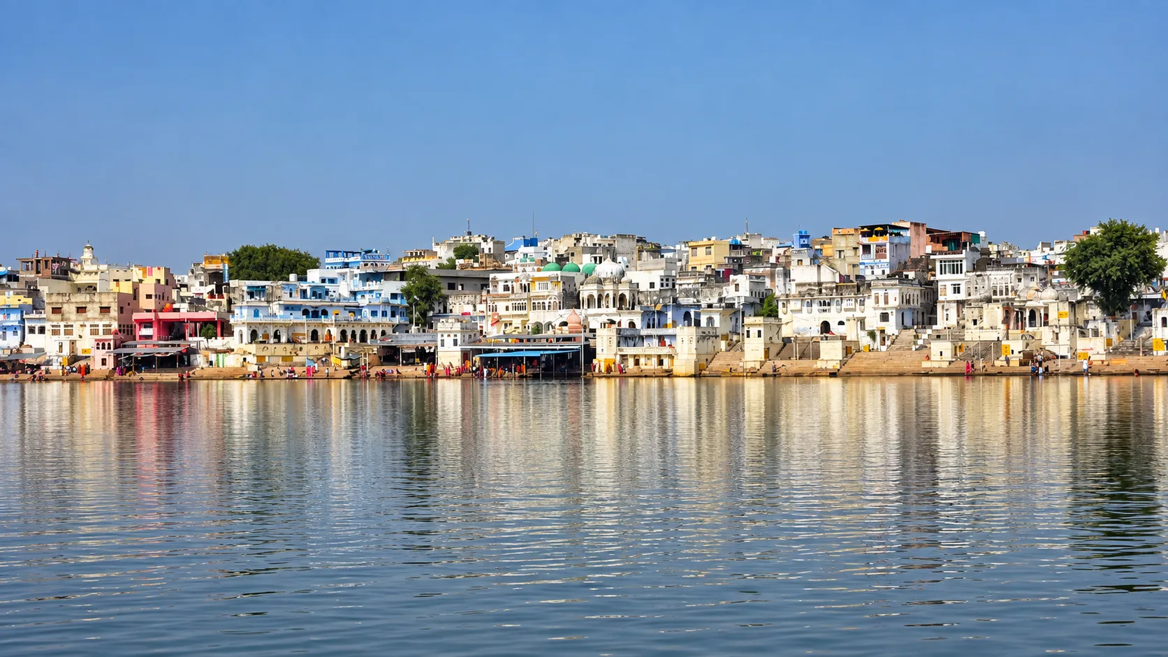 View of Pushkar Lake and the historic ghats surrounded by traditional buildings in Rajasthan