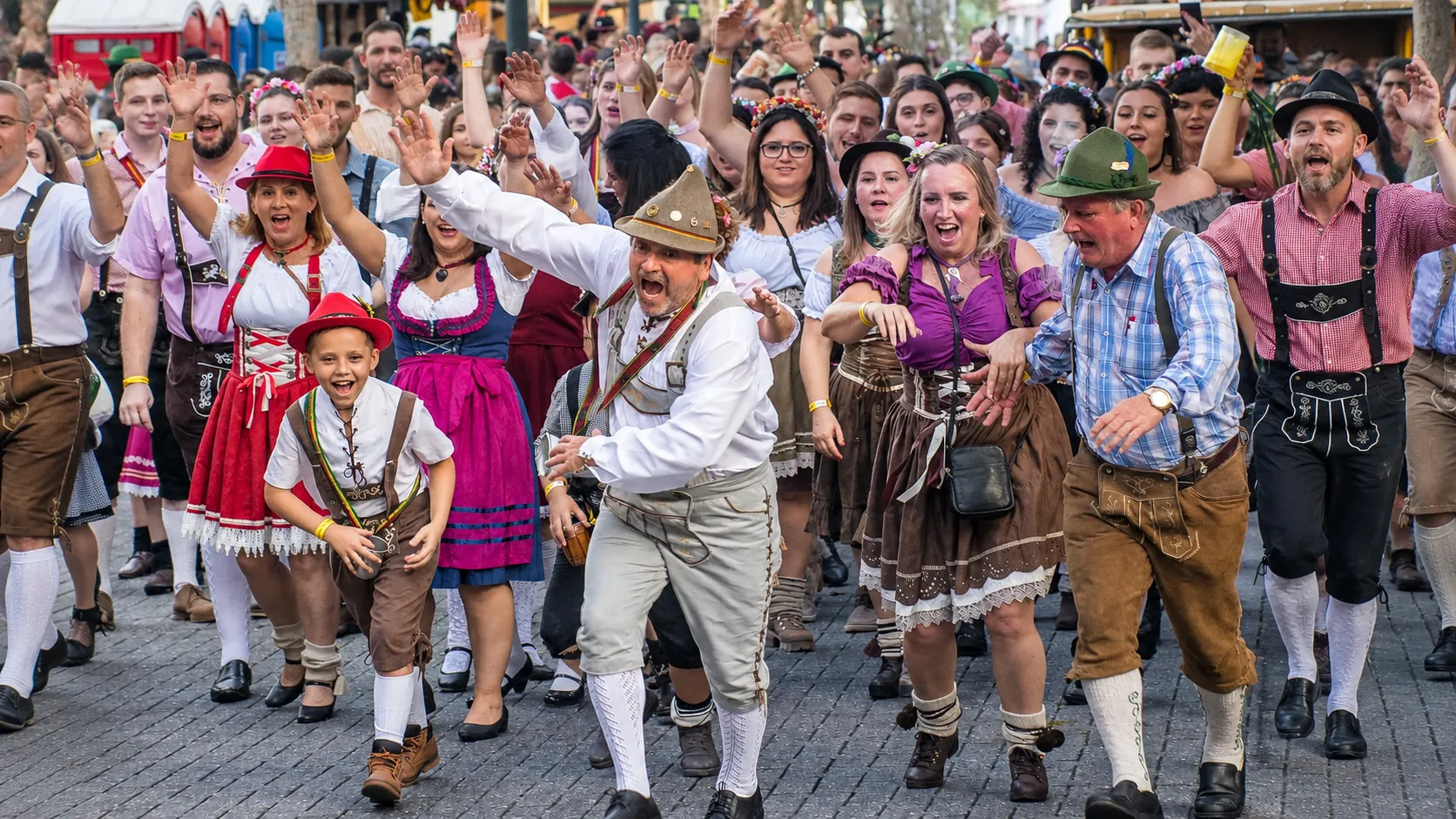 Large crowd in traditional Bavarian clothing celebrating at a lively German festival