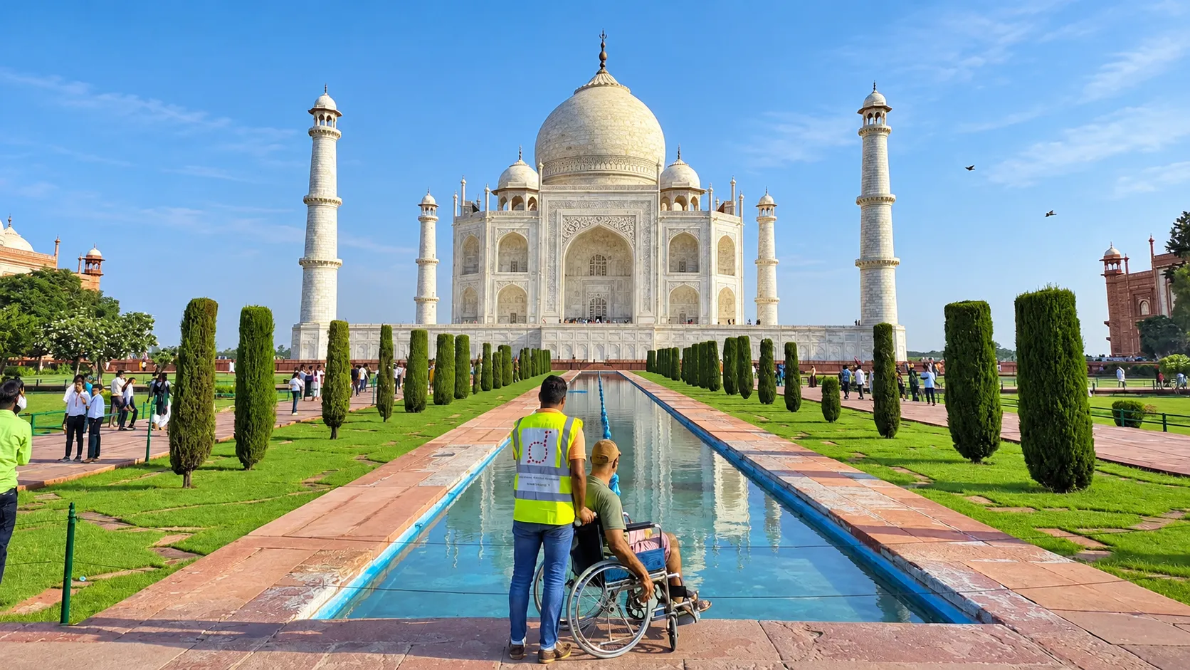Visitor using a wheelchair with assistance near the reflecting pool in front of the Taj Mahal.