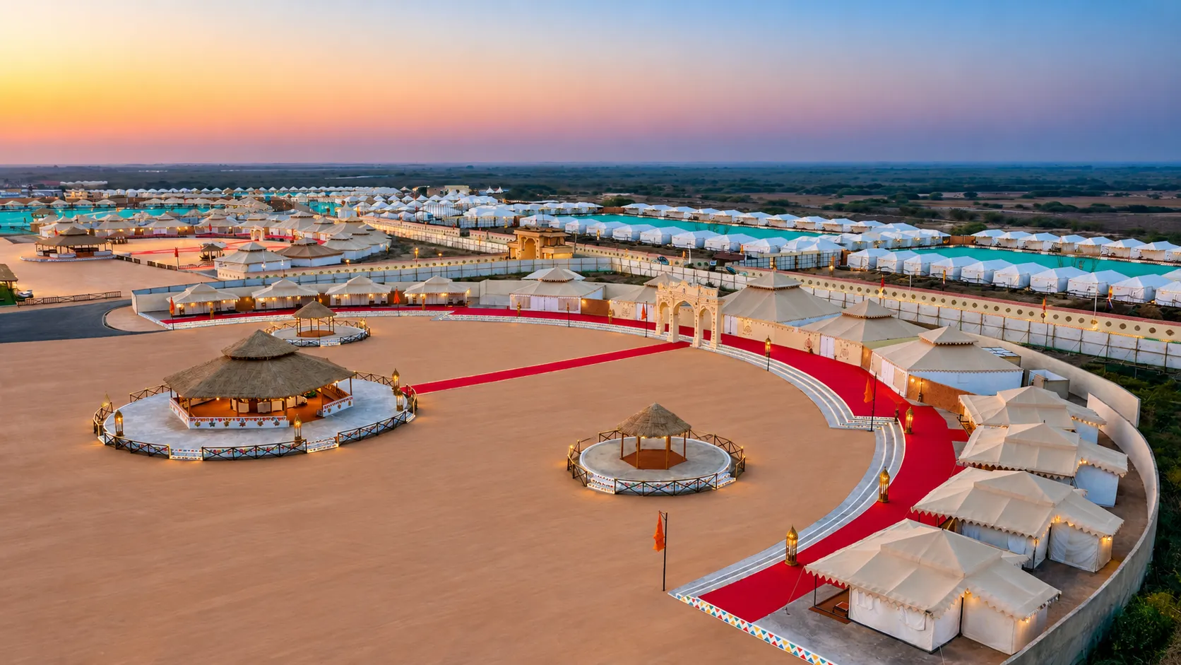 Aerial view of Rann Utsav Tent City featuring white luxury tents, red-carpeted pathways, and a decorative entrance gate
