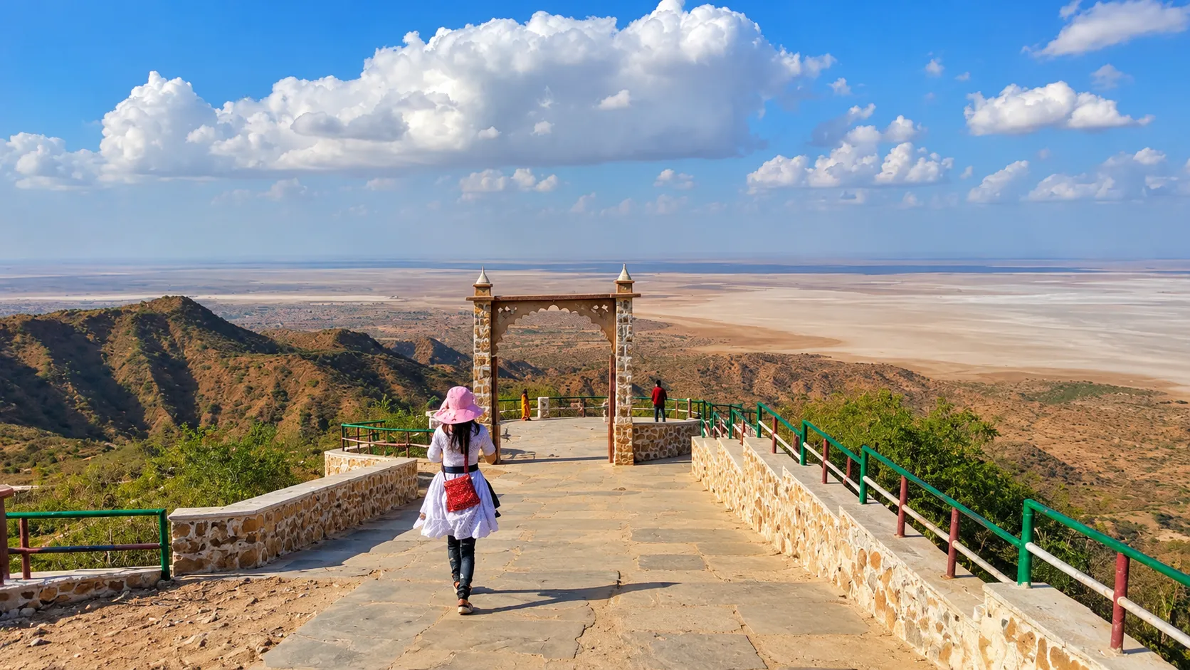 Stone pathway and decorative gateway overlooking the vast salt flats and rugged hills of the Rann of Kutch