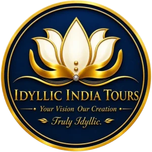 Idyllic India Tours logo featuring a gold and ivory lotus emblem on a navy blue circular background